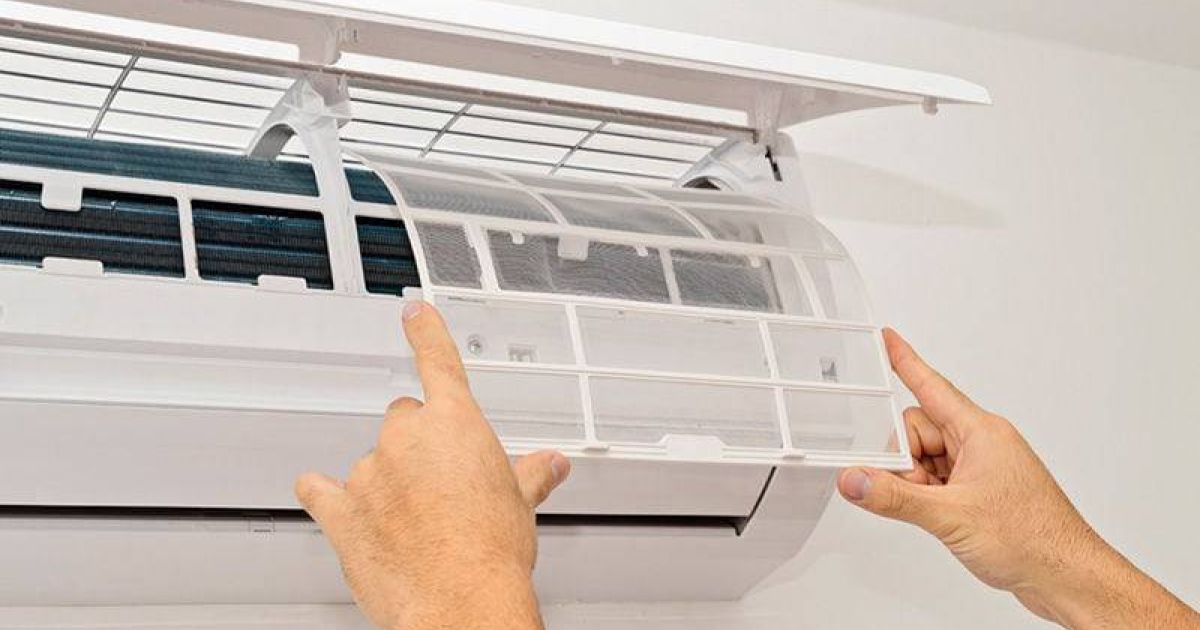Technician performing maintenance on a ductless AC system to prepare for Fort Collins summer heat.