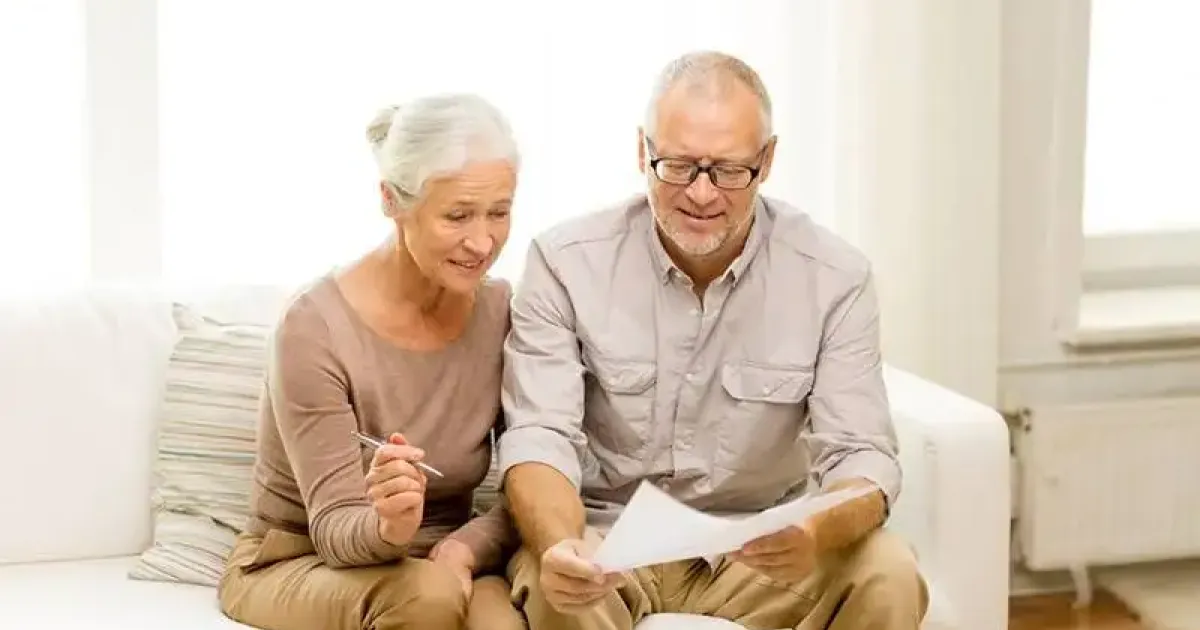 Elderly couple examining possible costs for repair on a not well-maintained furnace.