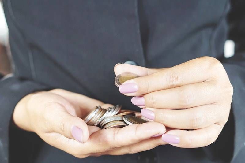 Homeowner holding a small stack of coins in their hands that they saved up.