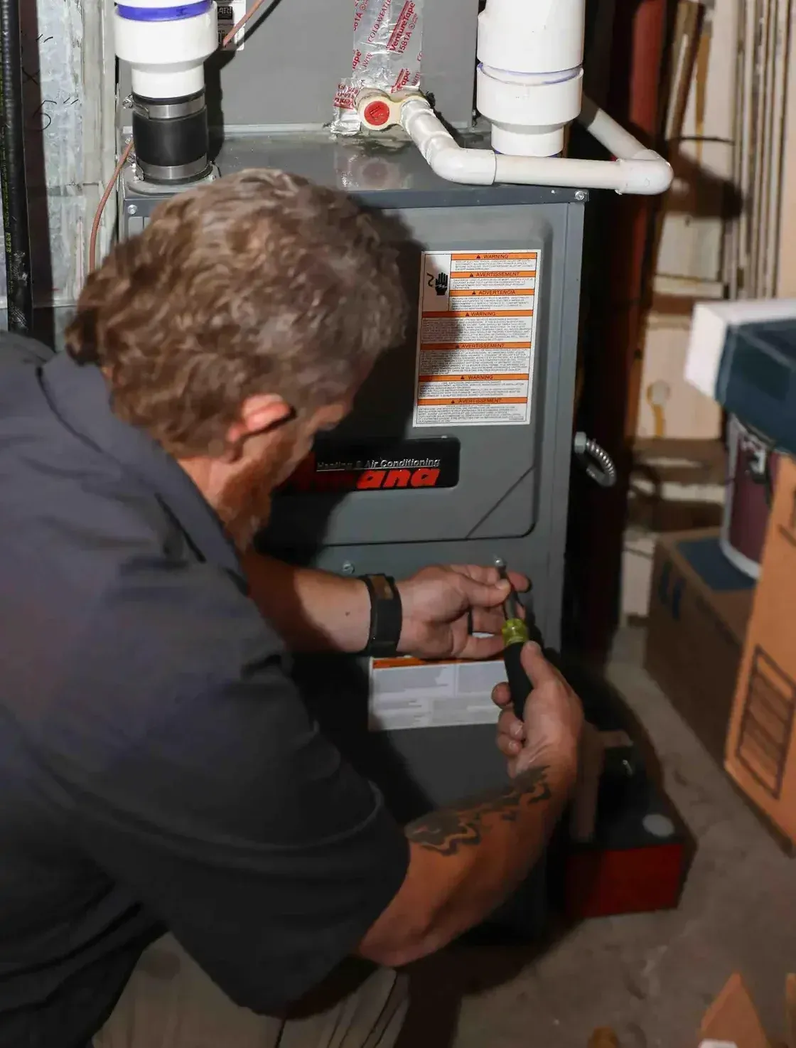 HVAC technician installing a furnace system in the basement of a residential house in Fort Collins.