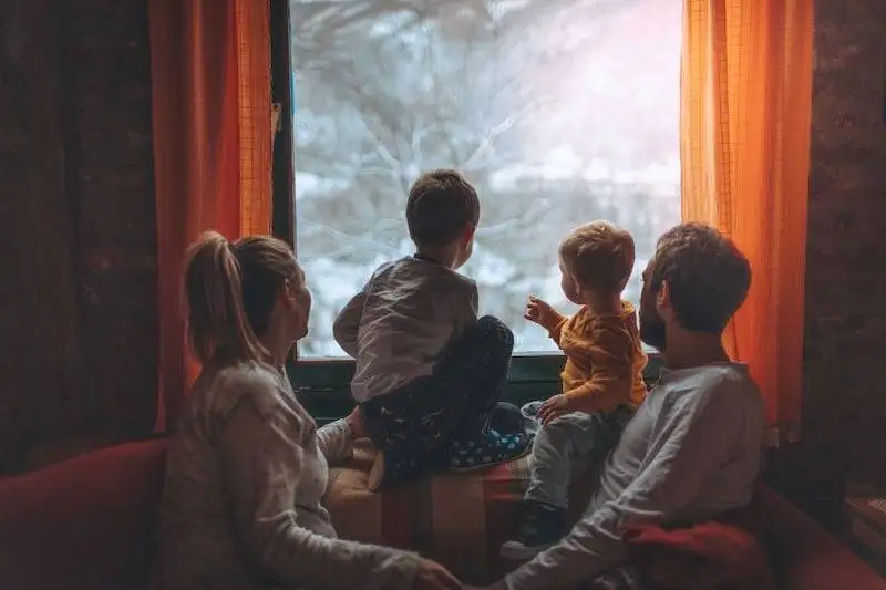 Family in a home with good indoor air quality in winter looking out the window.