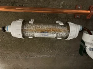 NC-1 condensate neutralization capsule installed by Balance Point Heating, Cooling & Plumbing on a high-efficiency system drain line in Loveland, CO