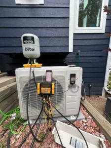 Fort Collins AC repair technician using electronic leak detection and recharging R-410A refrigerant on an outdoor condenser unit