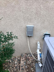 Fort Collins AC repair technician installing a new outdoor disconnect box and wiring to restore safe electrical operation of an AC system