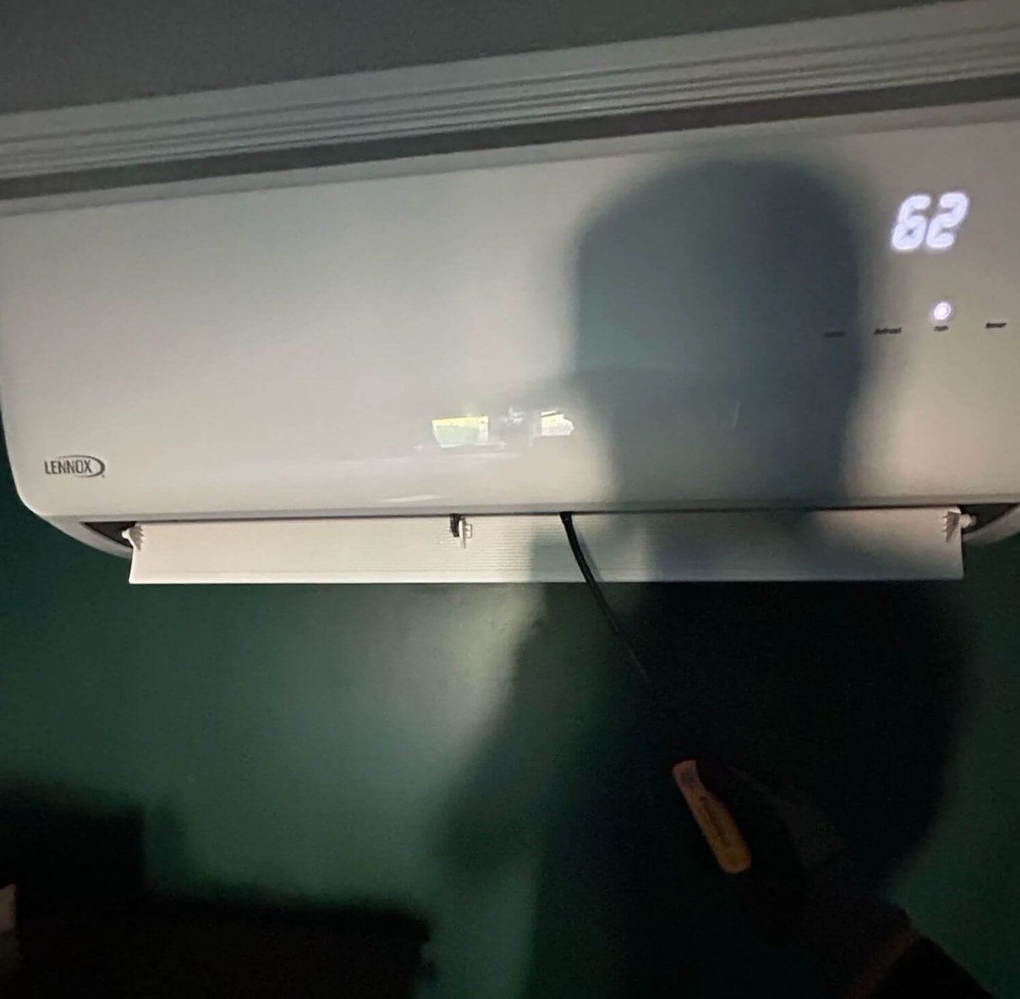 Technician inspecting a Lennox ductless mini split indoor head in a Fort Collins home served by Balance Point Heating, Cooling & Plumbing