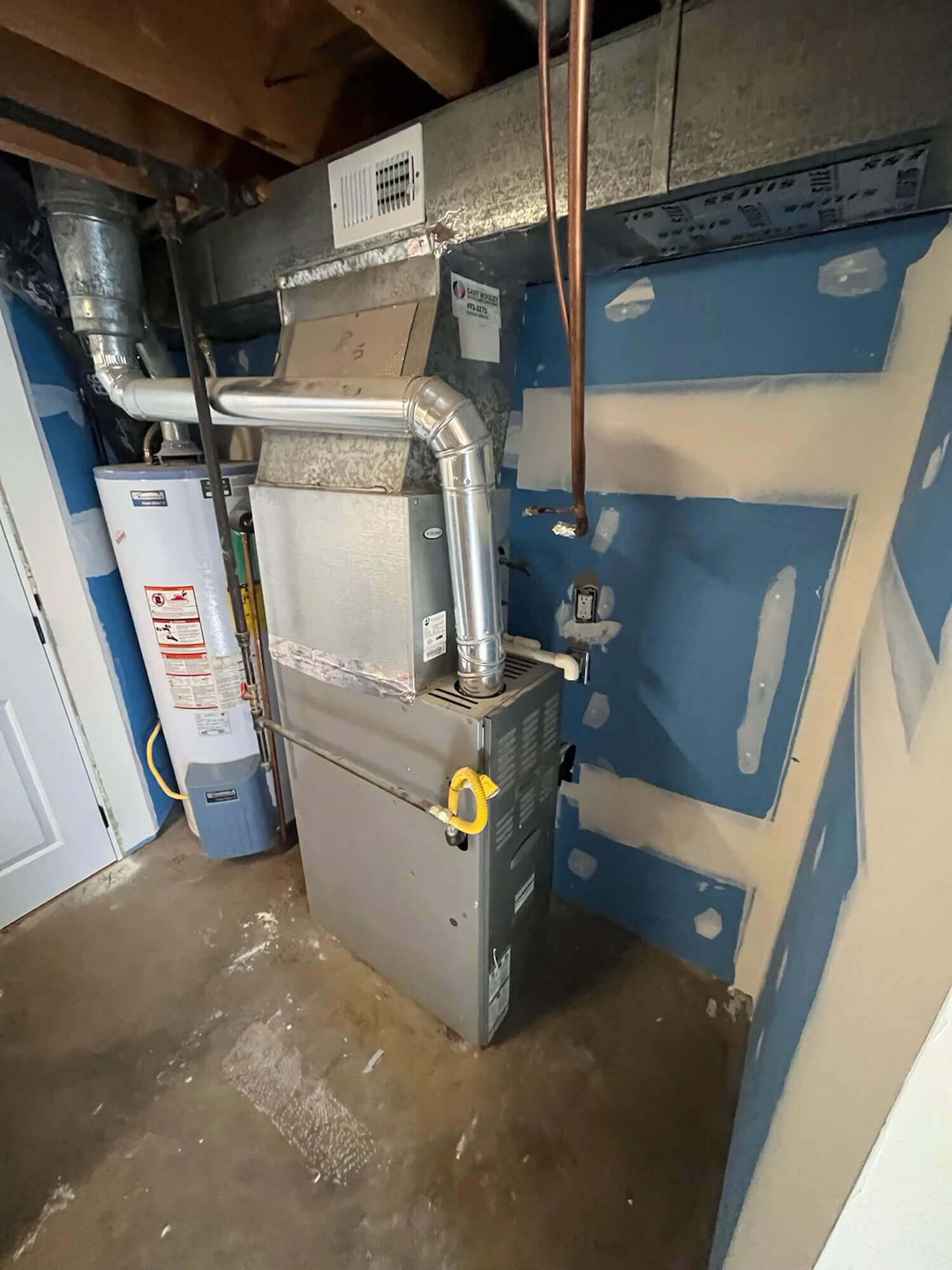 Gas furnace and water heater in a Fort Collins home utility room served by Balance Point Heating, Cooling & Plumbing