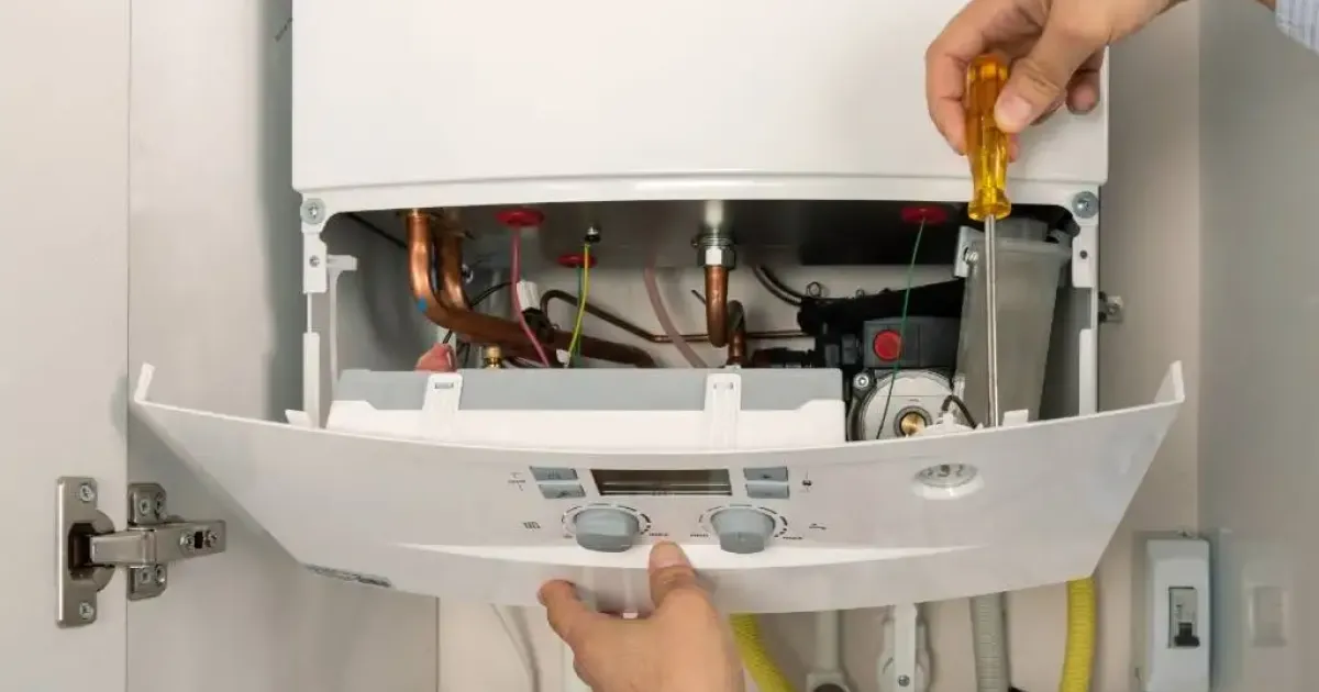 HVAC technician fixing the internal components of a boiler.