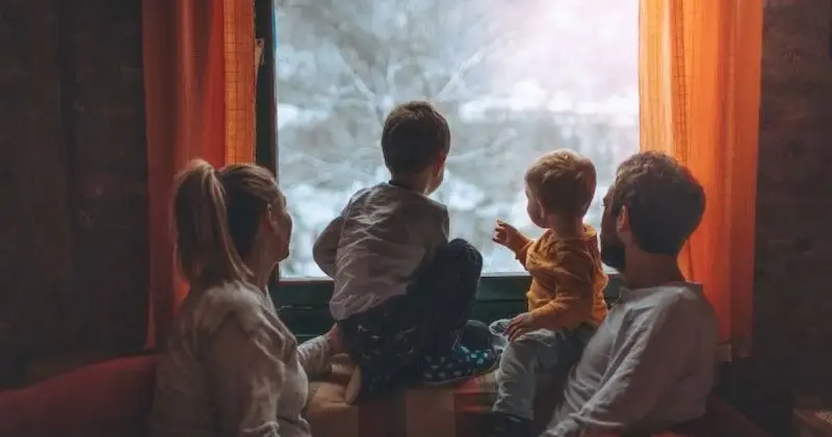 Family in a home with good indoor air quality in winter looking out the window.