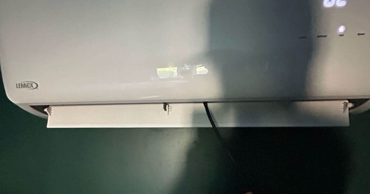 Technician inspecting a Lennox ductless mini split indoor head in a Fort Collins home served by Balance Point Heating, Cooling & Plumbing