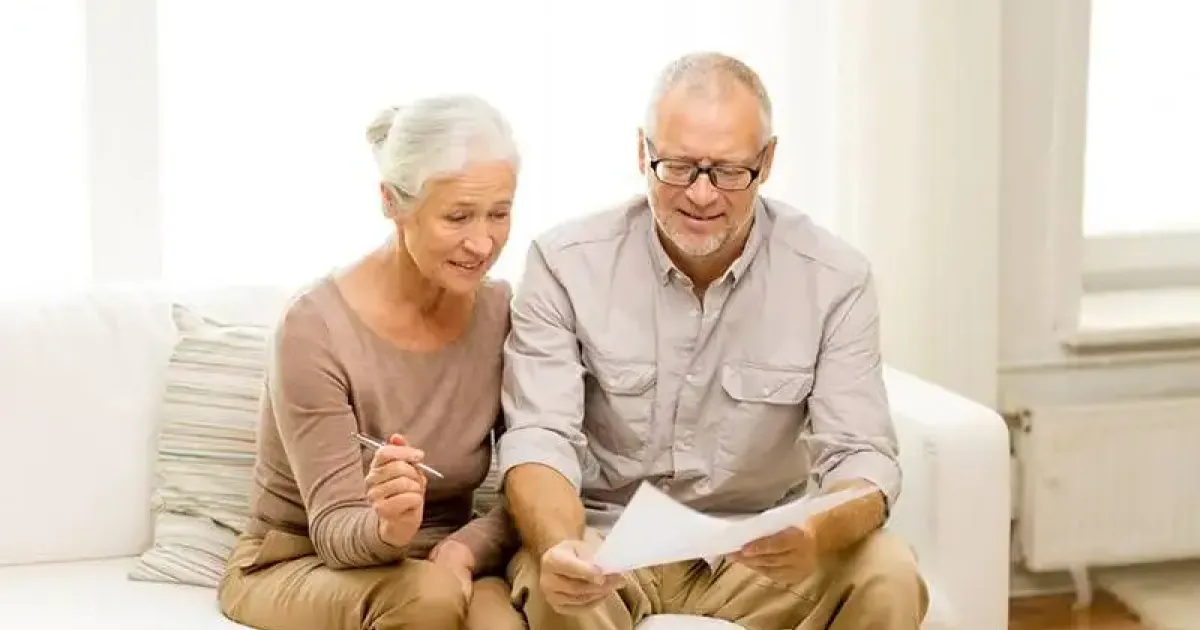 Elderly couple examining possible costs for repair on a not well-maintained furnace.